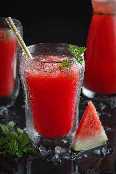 istock Summer cold drink with watermelon and mint on a black wooden background. Copy space 2204602442