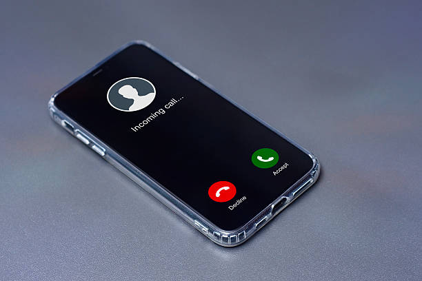 istock Smartphone displaying an incoming call screen with Decline and Accept buttons, placed on a sleek gray desk. 2204602620