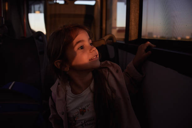 Portrait of a cheerful girl grimacing and laughing while traveling on a bus