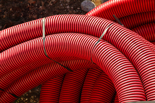 istock Red corrugated pipe for laying cables in the ground, as well as for use in drainage systems. 2204607600