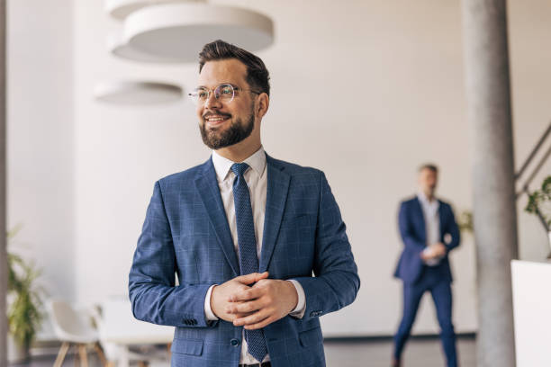 istock Young businessman smiling and looking away in modern office 2204611267