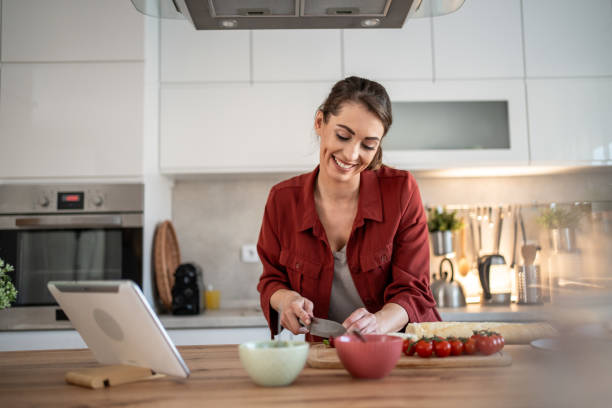 istock Smiling woman preparing a meal in a modern kitchen 2204611562