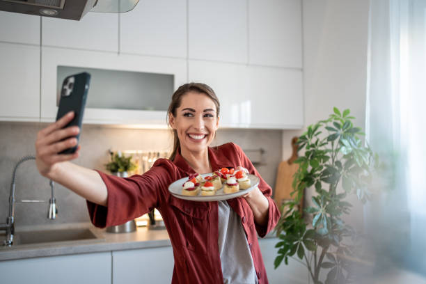 istock Food blogger taking a selfie with prepared appetizers in a modern kitchen 2204612051