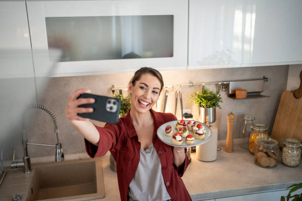 istock Food blogger taking selfie with prepared appetizers in kitchen 2204612111