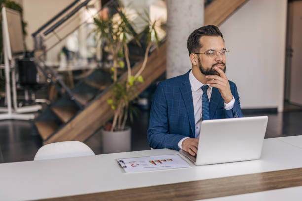 istock Pensive businessman working on laptop in modern office 2204612289