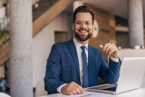 istock Young businessman smiling and working with laptop in modern office 2204612874