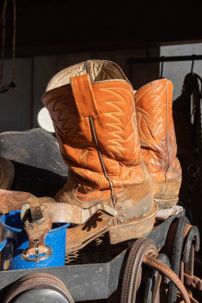 istock Old cowboy boots, stirrups, and straps. 2204614249