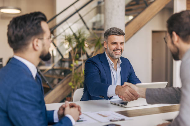 istock Businessmen shaking hands after successful meeting in modern office 2204614872