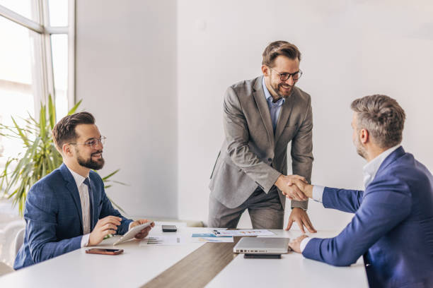 istock Businessmen shaking hands after successful meeting in office 2204615172
