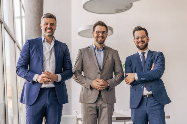 istock Three smiling businessmen posing in modern office 2204615463