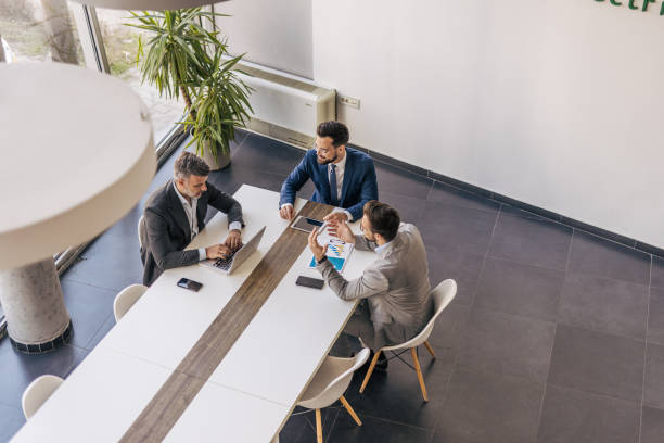 istock Businessmen working together at meeting table in modern office 2204615770