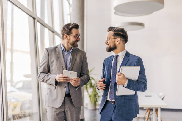 istock Two businessmen walking and talking in modern office 2204615968