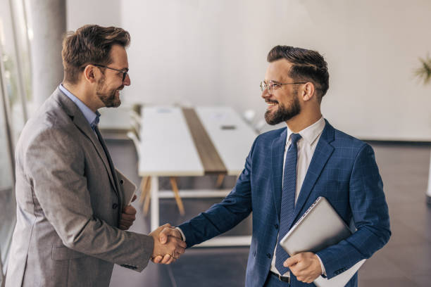 istock Two businessmen shaking hands after successful meeting in office 2204616058
