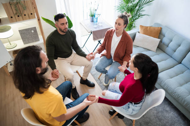 istock Group therapy session: patients holding hands and supporting each other 2204616689