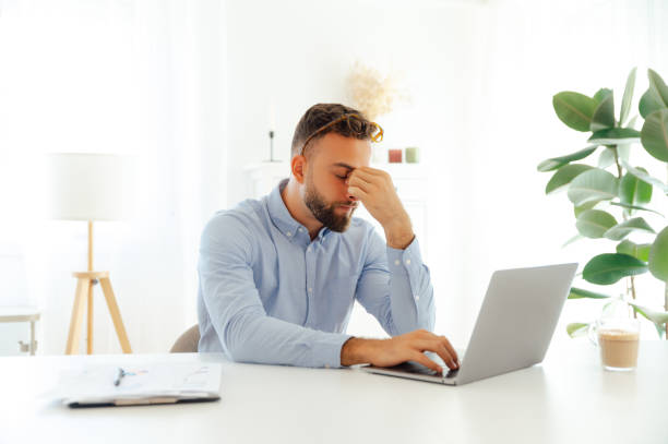 istock Exhausted sad caucasian or arabian businessman, experiences stress and overwork because of work challenges, massaging his nose bridge, closed his eyes, need coffee break 2204617396