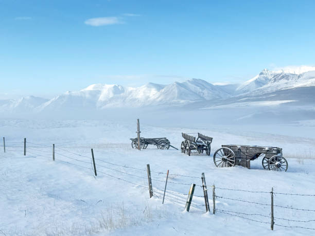 Three old carts against the Rockies in Southern Alberta, Canada.