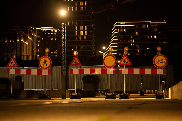 istock Construction Roadblock at Night with Illuminated Modern Buildings 2204617983