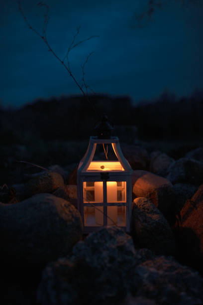 istock Glowing Lantern with Candlelight Among Stones at Night 2204618927