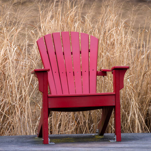istock Red Adirondack Chair by Park Walkway 2204621398