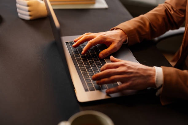 istock Businessman typing on laptop keyboard working at office desk 2204625441