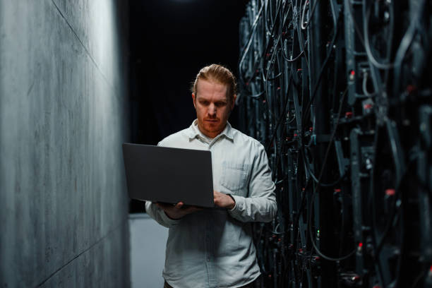 istock IT specialist working with laptop in server room 2204625599