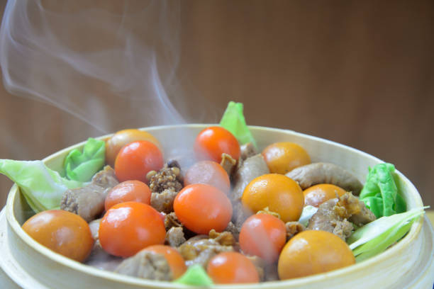 Steaming chicken offal in a steamer with rising steam