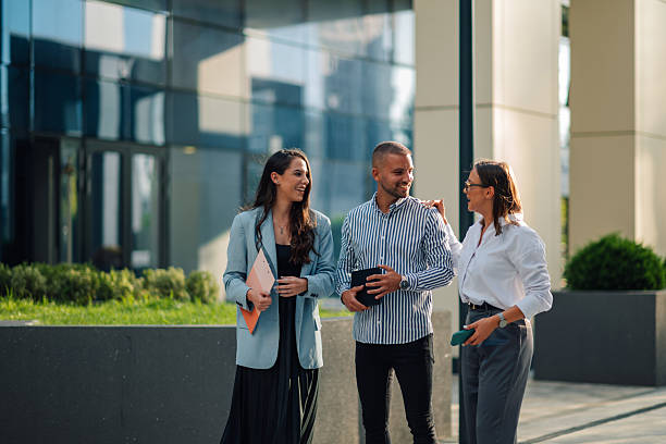 istock Three businesspeople having a conversation walking outside modern office building 2204634503