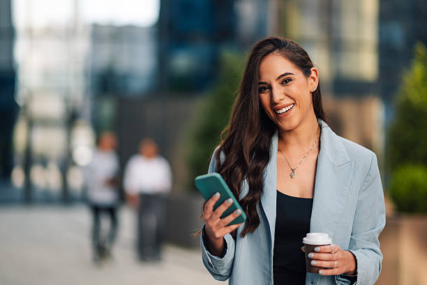 istock Businesswoman walking and using smartphone in city 2204634530