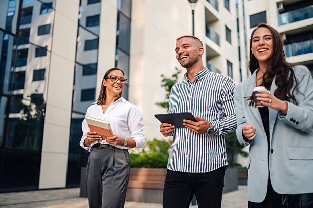 istock Business people walking outside office building and smiling 2204634533