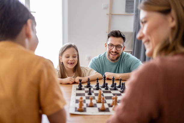 istock Family enjoys a chess game with kids laughing 2204635085