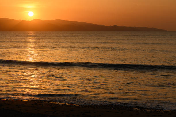 istock Vibrant sunset over calm ocean waves along a serene beach at dusk 2204635566