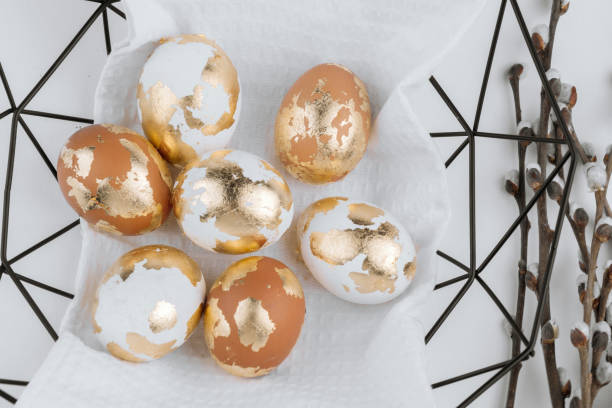 istock Easter golden eggs in a basket on a white background, top view. Easter festive banner. 2204637758