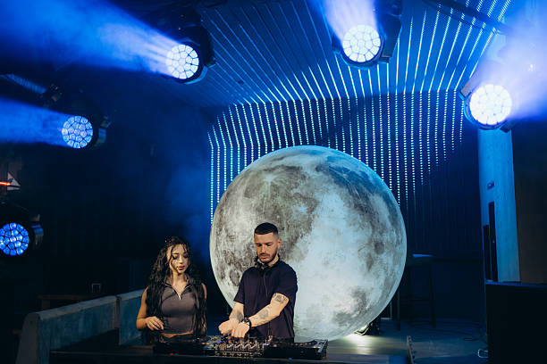 istock DJ Duo Performing Against a Lunar Backdrop at a Nightclub with Lights 2204637866