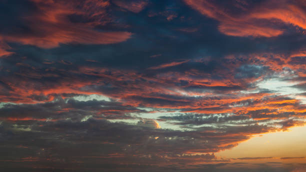 istock Panoramic view of a dramatic sunset sky with vibrant orange and deep blue clouds. 2204639175