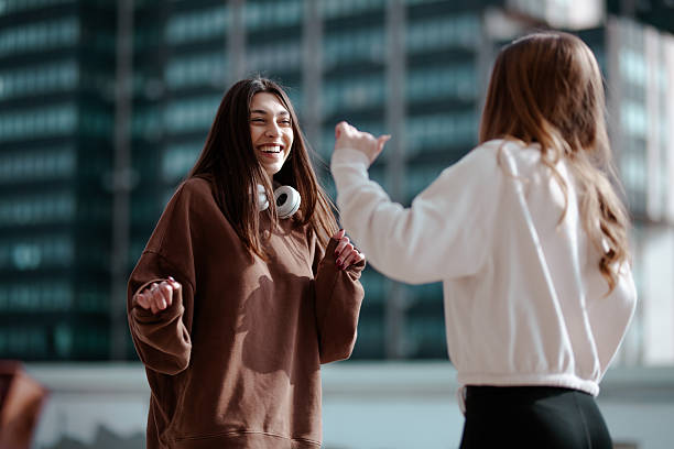 istock Cheerful young women interacting outdoors showcasing friendship and joyful connection 2204647793