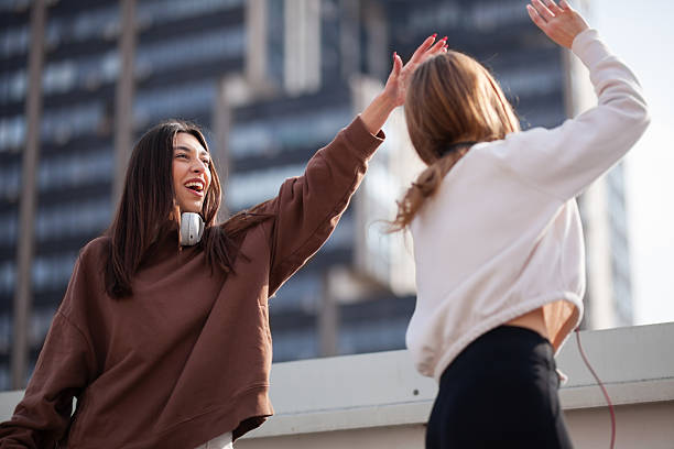 istock Two Friends Sharing a Cheerful Moment Outdoors with a High Five 2204647933