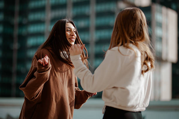 istock Two Young Women Enjoying Lively Conversation in an Urban Setting 2204647936