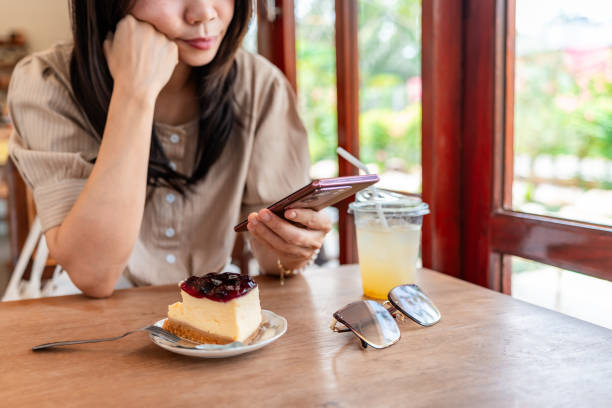 istock Stress and distraught young Asian woman using smart phone in cafe 2204651669
