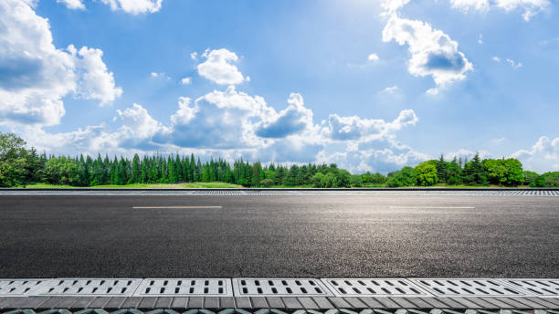 istock Asphalt road with green forest and clear blue sky in summer 2204653750