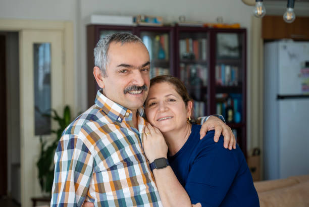istock Mature couple smiling portrait at home looking at camera 2204657666