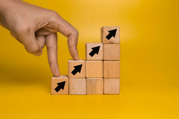 istock male hand walk on stack wooden blocks with arrow up isolated orange on background 2204657692