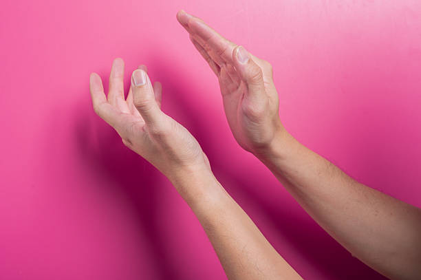 istock Two Asian hands captured in clapping motion against pink background, symbolizing applause, praise, success, encouragement, or recognition in dynamic and positive body gesture. 2204659162
