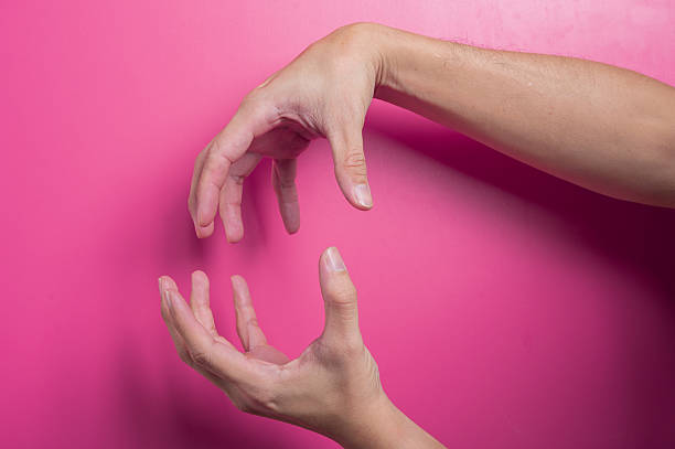 istock Two Asian hands with one arm crossing over in a defensive posture on pink background, symbolizing block, rejection, or disagreement in expressive and protective hand gesture. 2204659267