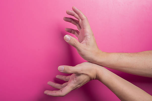istock Two Asian hands with one arm crossing over in a defensive posture on pink background, symbolizing block, rejection, or disagreement in expressive and protective hand gesture. 2204659373