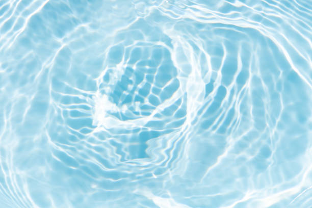 istock Blue water with ripples on the surface. Defocus blurred transparent blue colored clear calm water surface texture with splashes and bubbles. Water waves with shining pattern texture background. 2204660520