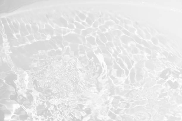istock White water with ripples on the surface. Defocus blurred transparent white colored clear calm water surface texture with splashes and bubbles. Water waves with shining pattern texture background. 2204660522