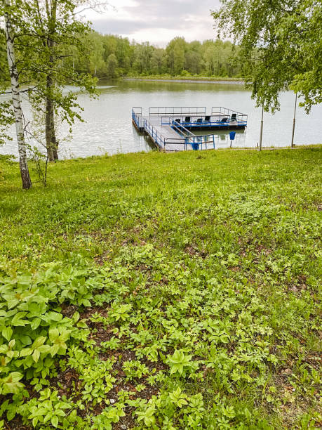 istock A small boat is peacefully docked by a serene and tranquil lake, where the calm and still waters perfectly reflect the stunning and beautiful surrounding natural scenery and landscapes 2204660734
