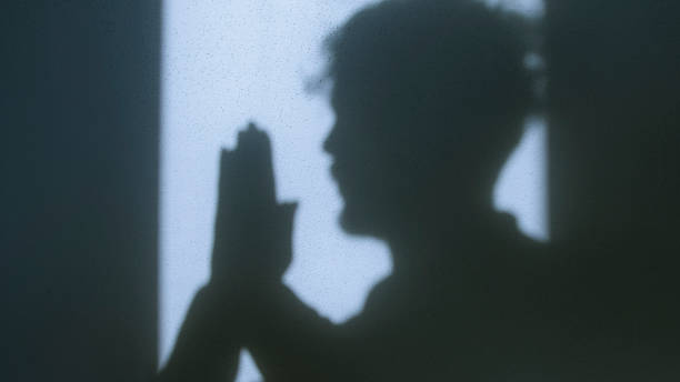 istock Shadow of a man in prayer with hands clasped in Christian devotion, symbolizing faith, spirituality, and connection with God 2204662848