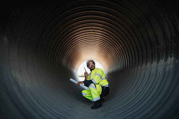 istock Engineers collaborate inside a massive steel pipe, constructing a tunnel for an industrial pipeline transporting oil, gas, and fuel. 2204662987