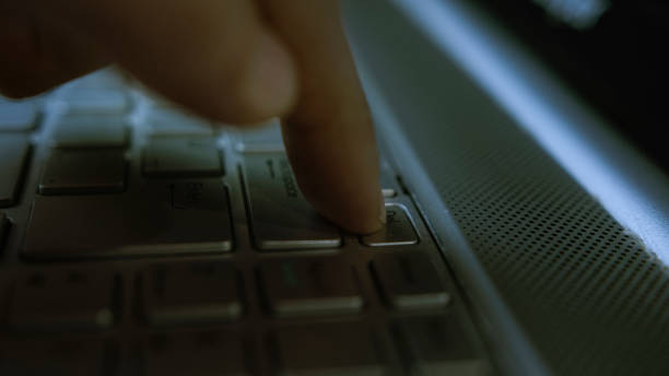 istock Close-up of a Finger Pressing the Delete Key on a Laptop Keyboard in Low Light 2204663405